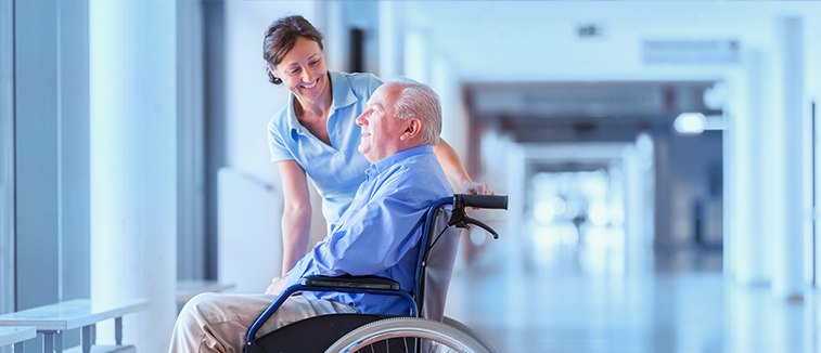 healthcare assistant nurse looking after elderly man in a wheelchair